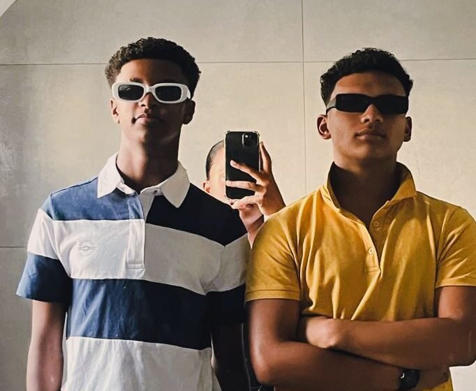 Two men taking a picture in the mirror.